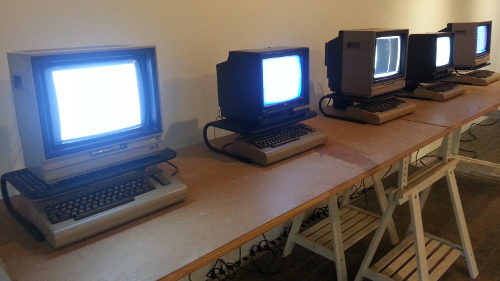 Five Commodore 64s running one-line programs